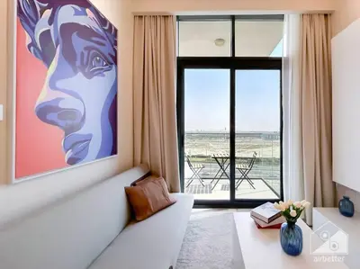a living room with a couch and a large window at Elegant 1BR with Balcony in Azizi Riviera in Dubai