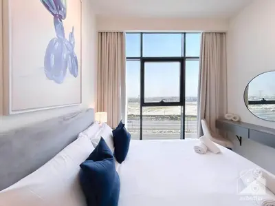 a bedroom with a white bed with a large window at Elegant 1BR with Balcony in Azizi Riviera in Dubai
