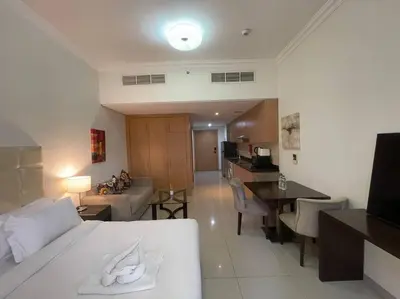 a hotel room with a bed and a living room at Studio Apartment in Dubai in Dubai