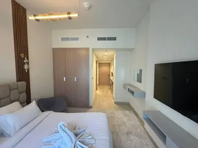 a bedroom with a bed and a flat screen tv at Stunning Studio in Meydan Azizi 42 in Dubai