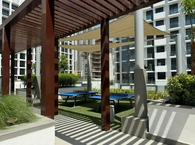 a group of picnic tables under a wooden pergola at Stunning Studio in Meydan Azizi 42 in Dubai