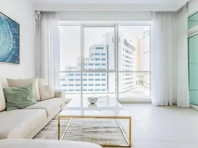 a living room with a couch and a large window at Seaside Elegance-1BR-Al Bateen-Private Beach Access in Dubai