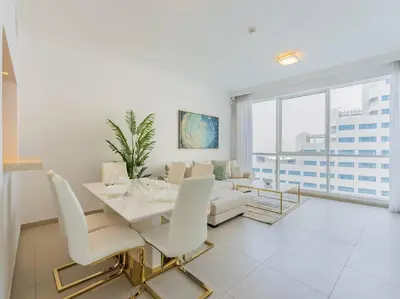 a white living room with a table and chairs at Seaside Elegance-1BR-Al Bateen-Private Beach Access in Dubai