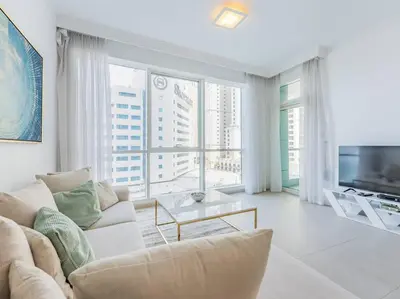 a living room with a couch and a tv at Seaside Elegance-1BR-Al Bateen-Private Beach Access in Dubai