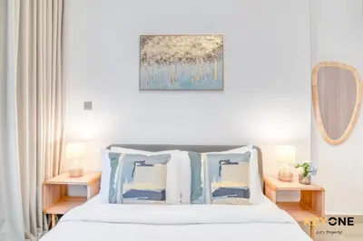 a bedroom with a bed with blue and white pillows at Spacious Azizi Riviera Studio in Dubai