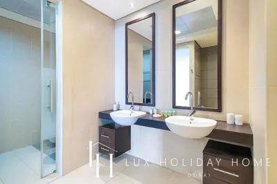 a bathroom with two sinks and two mirrors at LUX The Dream Palm Atlantis Sea View Suite in Dubai
