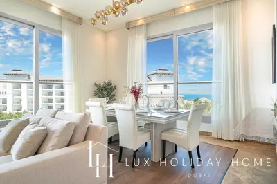 a dining room with a white couch and a table at LUX The Dream Palm Atlantis Sea View Suite in Dubai