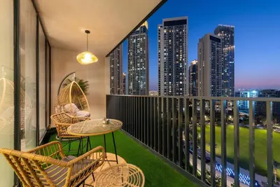 a balcony with chairs and tables and a view of the city at FIRST CLASS 2BR Stylish Bliss in Dubai