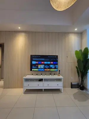 a flat screen tv sitting on top of a white cabinet at Bliss at the Fields, 5BR Villa with Garden in Meydan in Dubai