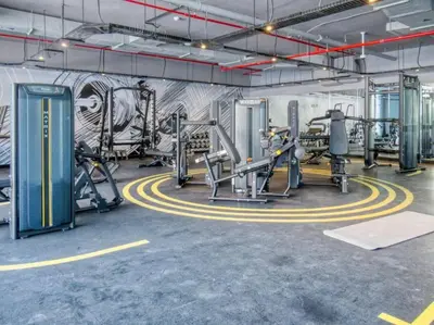 a gym with several tread machines and a wall with graffiti at Studio in Studio One Marina in Dubai
