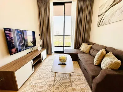 a living room with a couch and a tv at Modern 1br In Jvc Fully Furnished & Balcony in Dubai