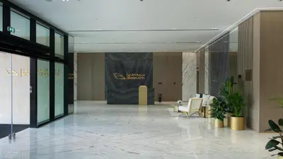 a lobby with chairs and a sign in a building at Modern 1br In Jvc Fully Furnished & Balcony in Dubai