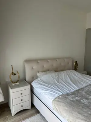 a bedroom with a white bed and a white nightstand at 2 Bedroom in Noora Tower, Fully furnished, Sea View in Dubai