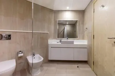 a bathroom with a sink and a toilet and a mirror at Luxury stay Private Beach Access in Dubai