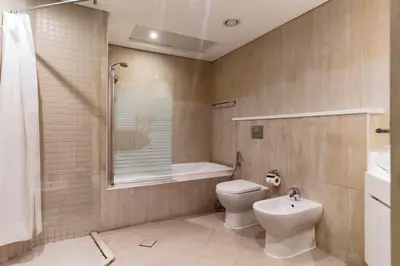 a bathroom with a toilet and a shower and a sink at Luxury stay Private Beach Access in Dubai