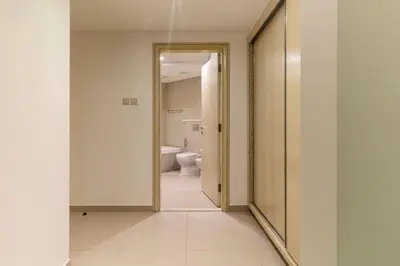 a hallway with a bathroom with a toilet and a mirror at Luxury stay Private Beach Access in Dubai