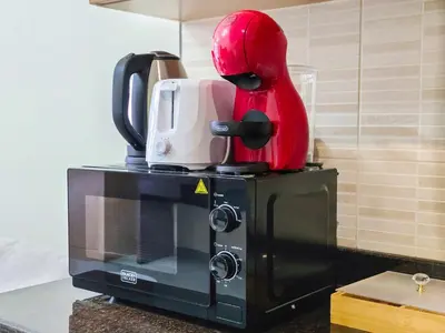 a red helmet is sitting on top of a microwave at EasyGo -Stylish STU With pool view Linkin park Arjan- 17 in Dubai
