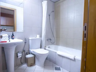 a bathroom with a toilet and a sink and a tub at EasyGo -Stylish STU With pool view Linkin park Arjan- 17 in Dubai