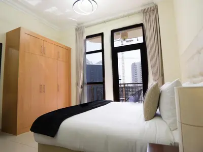 a bedroom with a bed and a large window at EasyGo -Stylish STU With pool view Linkin park Arjan- 17 in Dubai