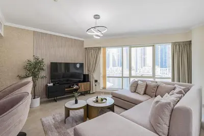 a living room with a couch and a television at Luxurious Waterfront at Al Majara Dubai Marina in Dubai