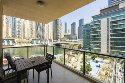 a balcony with a table and chairs and a view of a city at Luxurious Waterfront at Al Majara Dubai Marina in Dubai