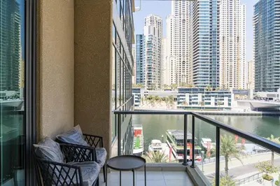 a balcony with two chairs and a view of a city at Luxurious Waterfront at Al Majara Dubai Marina in Dubai