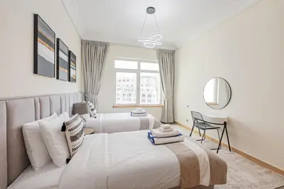 a bedroom with two beds and a window at DVH Al Hamri Jumeirah Shoreline 2 Bed & Maids Free beach access in Dubai