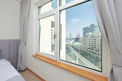 a bedroom with a window with a view of a city at DVH Al Hamri Jumeirah Shoreline 2 Bed & Maids Free beach access in Dubai