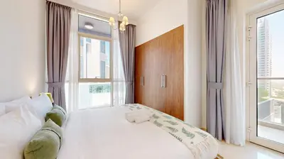 a bedroom with a bed and a large window at Vacationer I Sophisticated 1 Bedroom Apartment I Steps from Dubai Mall & Burj Khalifa I Dunya Tower in Dubai