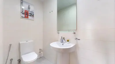 a white bathroom with a toilet and a sink at Vacationer I Sophisticated 1 Bedroom Apartment I Steps from Dubai Mall & Burj Khalifa I Dunya Tower in Dubai
