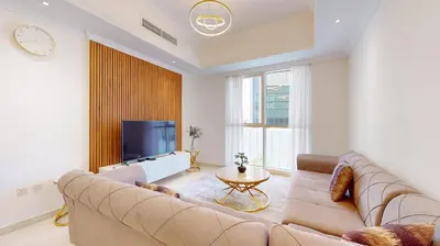 a living room with a large couch and a tv at Vacationer I Sophisticated 1 Bedroom Apartment I Steps from Dubai Mall & Burj Khalifa I Dunya Tower in Dubai