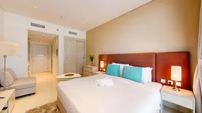 a bedroom with a large white bed and a couch at Seven Hotel and Apartment - Chic Studio in the Palm in Dubai