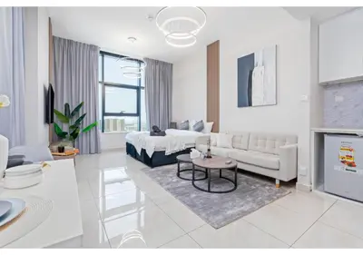 a white living room with a bed and a couch at Bright Resort Style Studio Amenities Samana GA by Vibel in Dubai