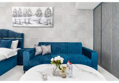 a living room with two blue couches and a table at Bright Resort Style Studio Amenities Samana GA by Vibel in Dubai