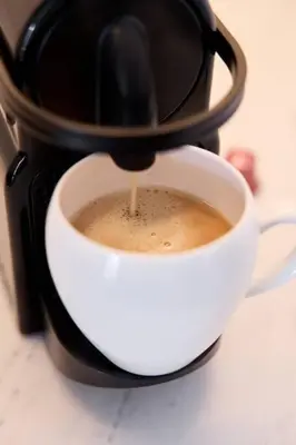 a coffee maker is making a cup of coffee at Elegant Luxury Living in Palace Residences in Dubai