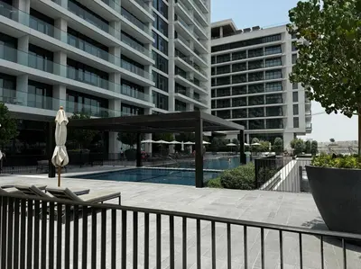 a large building with a swimming pool and a umbrella at Elegant Luxury Living in Palace Residences in Dubai