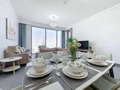 a living room with a table with dishes on it at FAM Living - Spacious 3-Bedroom Apartment in Creek Gate with Stunning Views in Dubai