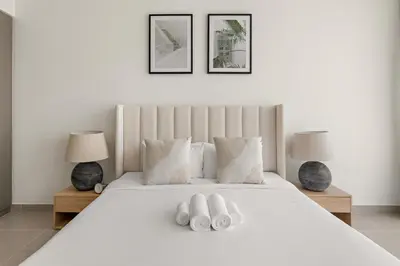 a bedroom with a white bed with two towels at Superb 1Bed With Pool & Gym near the Burj Khalifa in Dubai