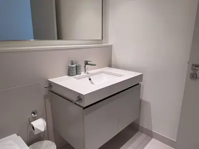 a white bathroom with a sink and a mirror at 2 Bed - Sunrise Bay Views in Dubai