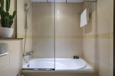 a bathroom with a tub with a glass shower door at GuestReady - Lux home amid Dubai Marina and JBR in Dubai