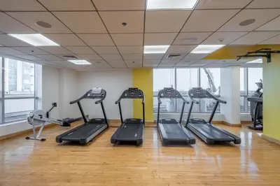 a gym with treadmills and ellipticals in a room at GuestReady - Lux home amid Dubai Marina and JBR in Dubai