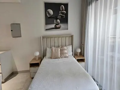 a bedroom with a bed with two tables and a window at Luxury Studio in Jumeirah Village Circle in Dubai