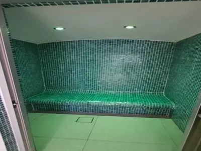 a green tiled shower with a green bench in a room at Luxury Studio in Jumeirah Village Circle in Dubai