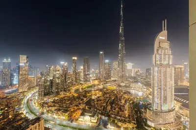 a view of a large city at night at Full Fountain and Burj View - 3BR Burj Royale in Dubai