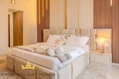 a bedroom with a large white bed with towels on it at Royal suites Dunya tower Burj Khalifa St Kings in Dubai