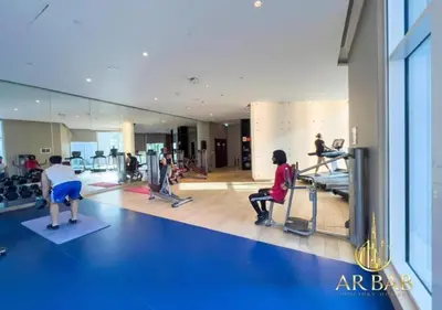 a group of people exercising in a gym at Damac Maison Prive - Luxury Studio - Burj Khalifa View in Dubai
