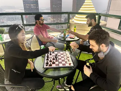 a group of people sitting around a table playing chess at Pathfinder Partition Room in Barsha Heights Tecom in Dubai