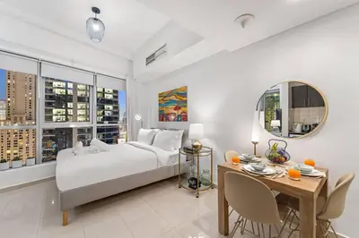 a bedroom with a bed and a desk and a table with chairs at FIRST CLASS Studio Cozy Urban Retreat in Dubai