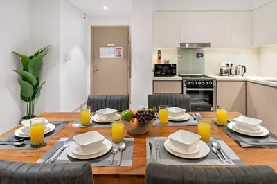a dining room with a table with plates and glasses of orange juice at FIRST CLASS Luxury 2BR in Creek Harbour Pool, Gym, Walk to Dining in Dubai