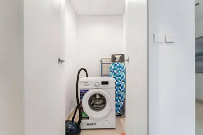 a laundry room with a washer and a washing machine at FIRST CLASS Luxury 2BR in Creek Harbour Pool, Gym, Walk to Dining in Dubai